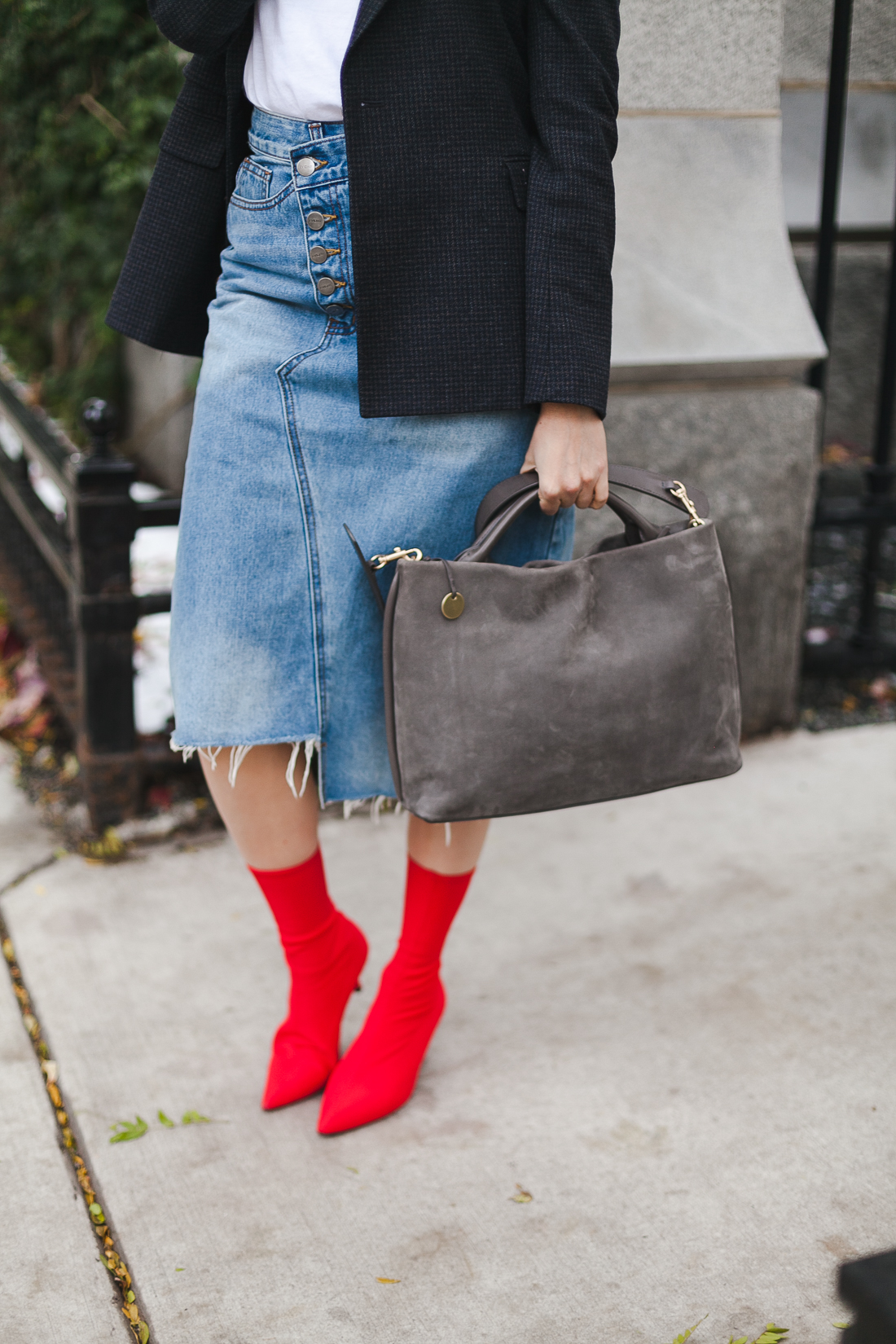 Yana Frigelis of NoMad Luxuries wearing a graphic tee under a blazer with red sock boots and a jean retro skirt for Fall