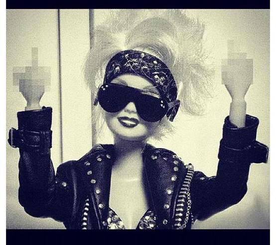 Nomad Luxuries; vintage black and white photo of a Barbie Doll using profanity.