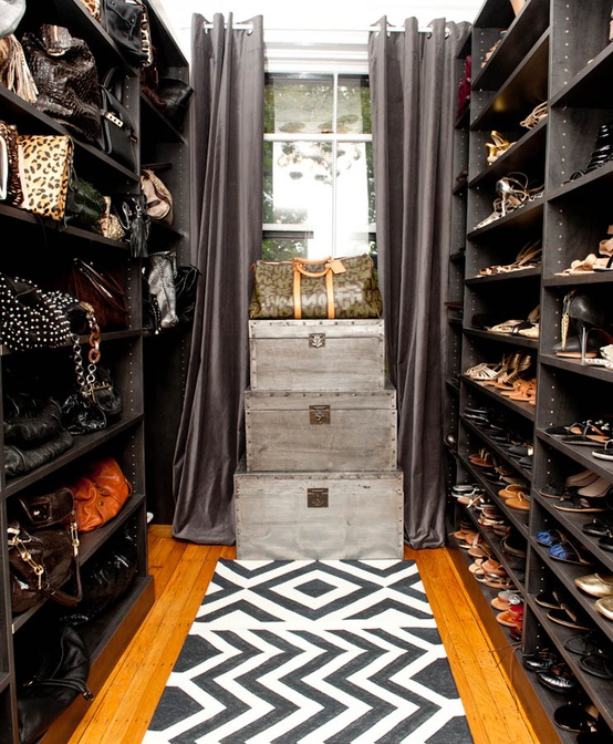 Nomad Luxuries photo of black-themed walk in closet with black and white detailing. 