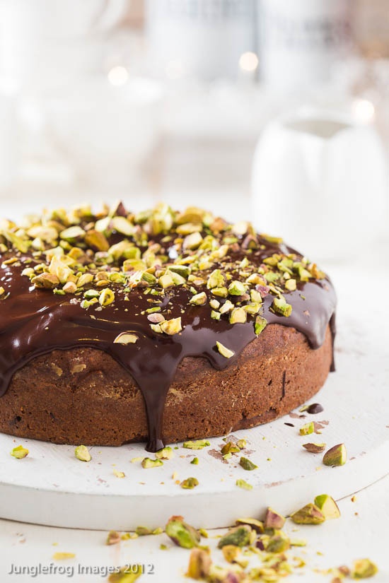 Nomad Luxuries chocolate one layered cake topped with chocolate glaze and roasted pistachios. 