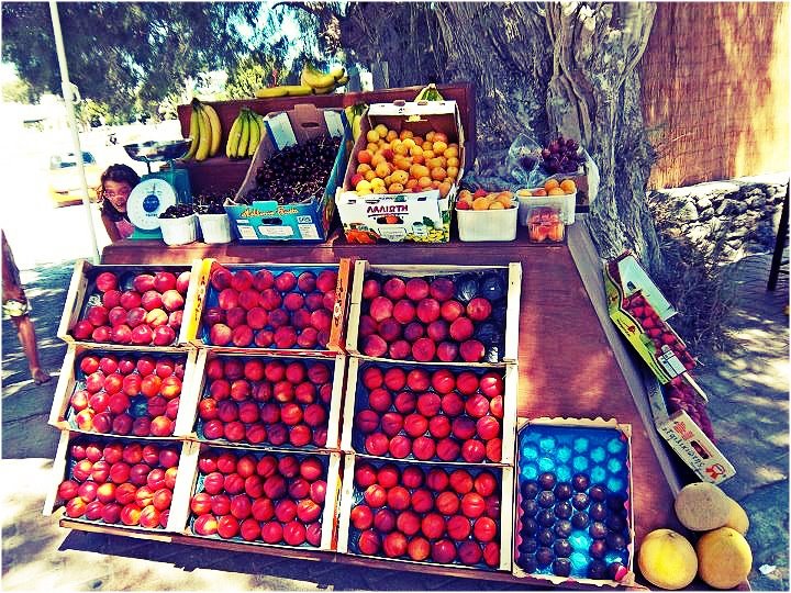 Nomad Luxuries image of the organic fruit stand in the streets of Santorini. 