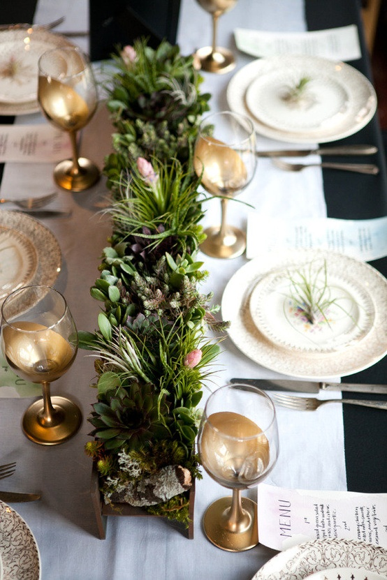 Nomad Luxuries dining table decor incorporating a green centerpiece