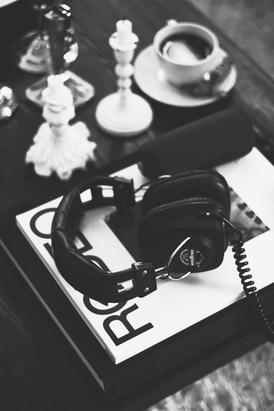 Nomad Luxuries black and white photo of coffee table with headphones. 