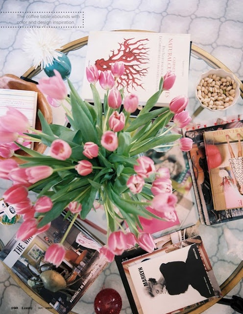 Nomad Luxuries; pink tulips towering over a spread of books 