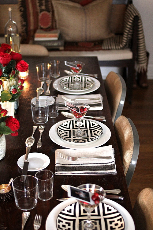 Nomad Luxuries; black and white themed dining table with red accents. 