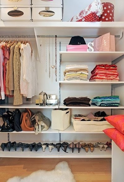 Nomad Luxuries photo of organized clothing closet with pops of pink and red for color. 