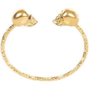 Nomad Luxuries image of gold skull bracelet as an accessory for oxblood attire. 