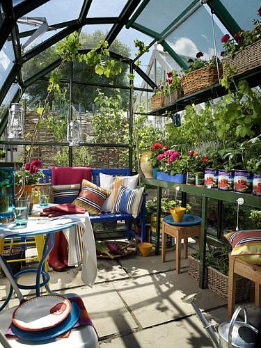 Nomad Luxuries photo of an urban greenhouse with DIY planters and colorful decor. 